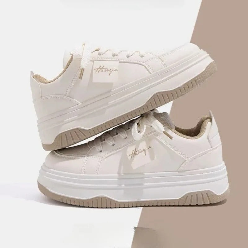 Snygga vita chunky sneakers för dam i sidoprofil, med tjock sula och trendiga snördetaljer.