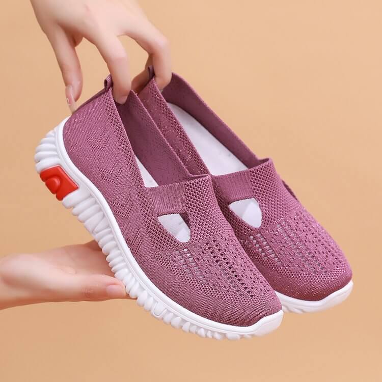Detaljbild av snörning på vita andningsbara canvas-sneakers för kvinnor.