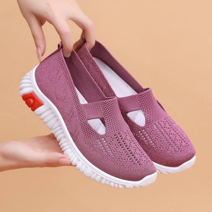 Detaljbild av snörning på vita andningsbara canvas-sneakers för kvinnor.