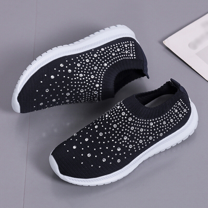 Två vita slip-on damsneakers i mesh med strass, andningsaktiva och bekväma för dagsbruk.