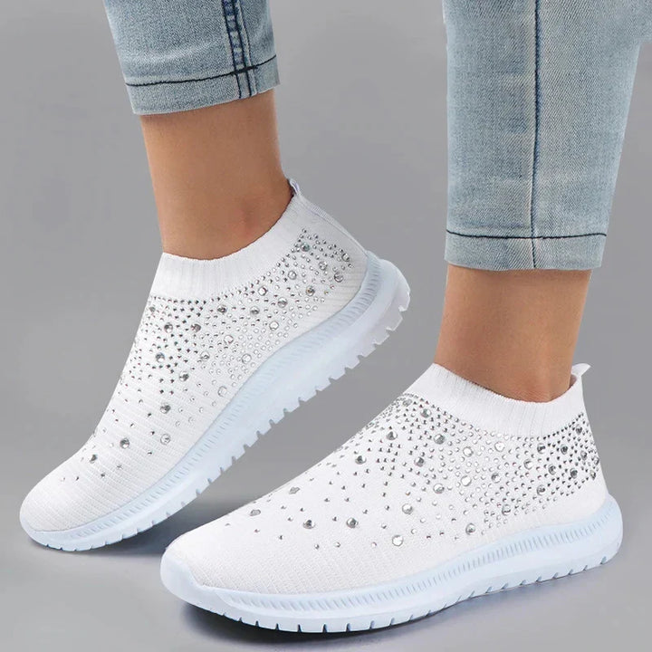 Sidovy av vita meshskor för damer med strass, en bekväm och andningsaktiv sneaker för damer.