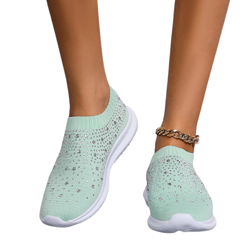 Damsneakers i vit mesh och strass på en fot, som visar hur de sitter bekvämt under dagsbruk.