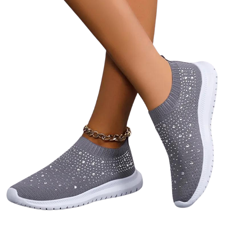 Detaljbild på de glittrande strassutsmyckningarna på en vit damsneaker av ventilerande mesh.