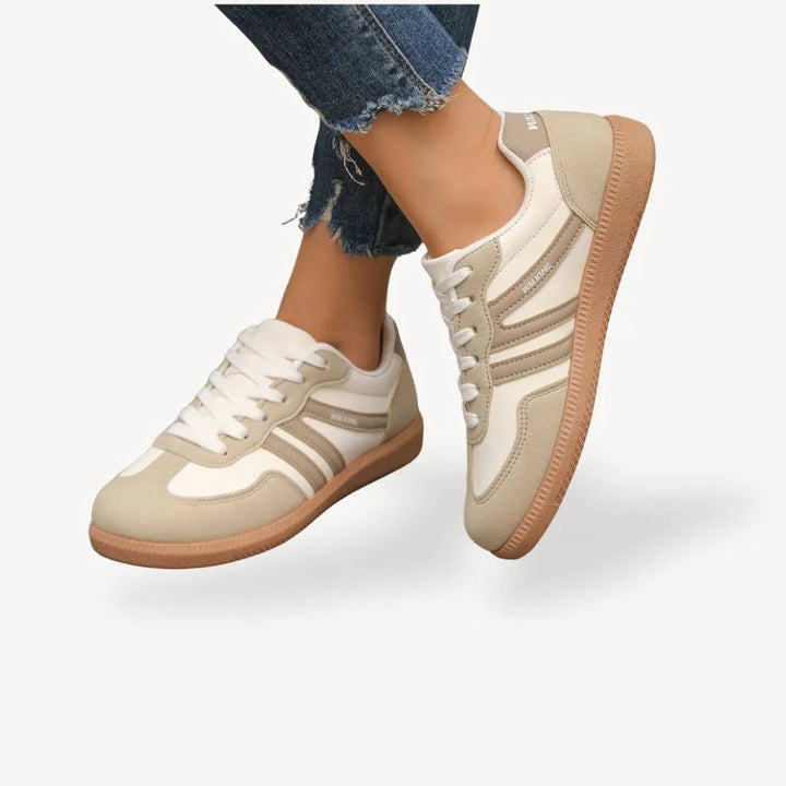 Detaljbild av bekväma dam sneakers med låg profil, vita snören och mjuk sula för promenader.