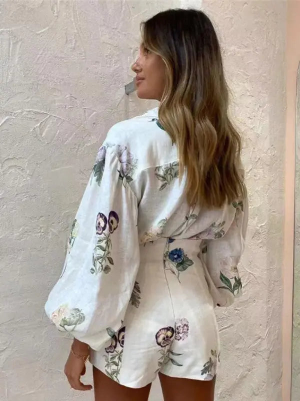 Elegant vitt damset med luftig blommönstrad blus & bekväma högmidjade shorts. Modern sommarstil.